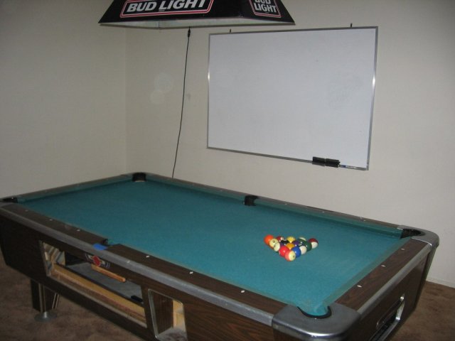 The pool table (marble slate) and the white board. Note the bar light above the table.