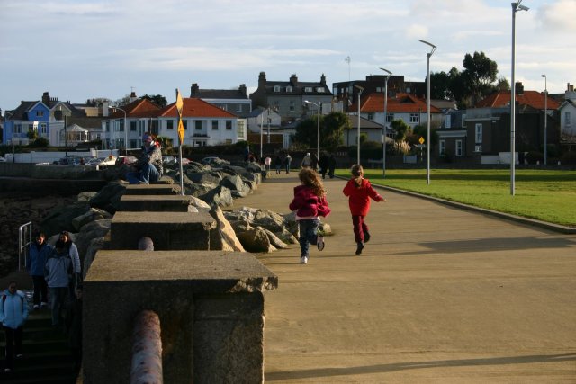 Kids running down the walkway near teh ocean in Dun Laoghaire.