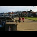 Kids running down the walkway near teh ocean in Dun Laoghaire.