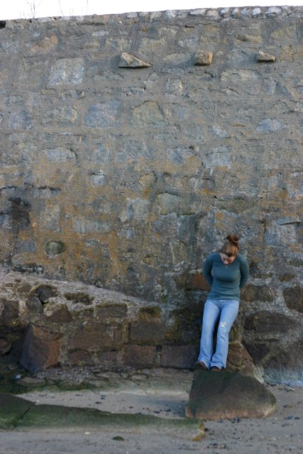 Leilani leaning up against the retaining wall at low tide.