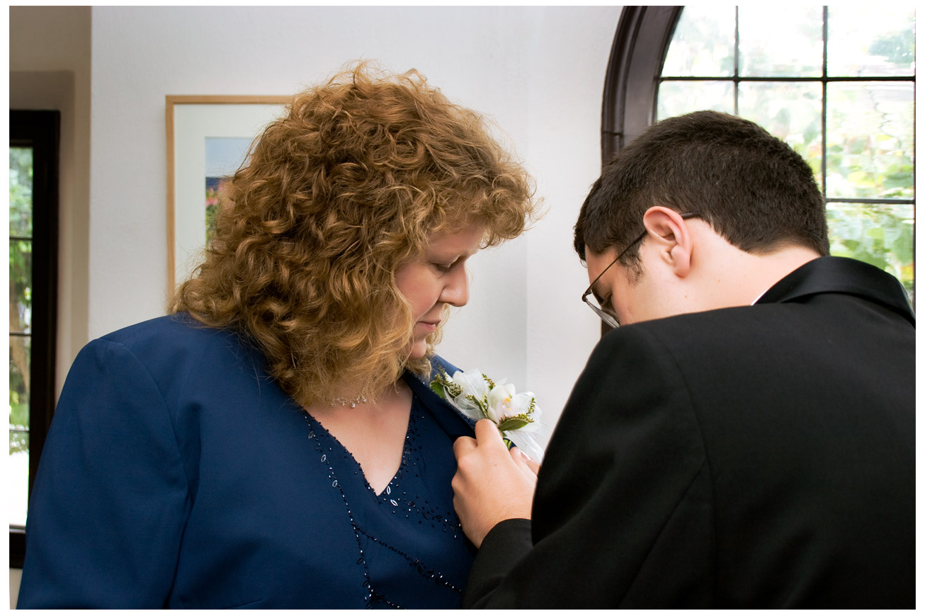 Jason pinning on a corsage on his Mom.